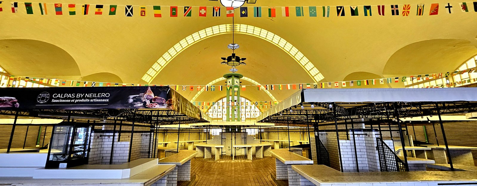 Market stalls beneath a light-filled hall structure in Rouen.